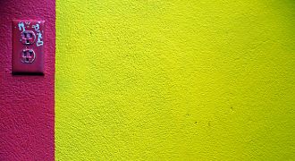 Un mur jaune avec une bande rose.