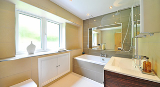 Salle de bain avec baignoire et fenêtre dont le décor privilégie le bien-être.