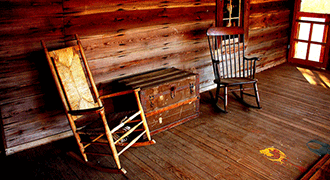 Deux rocking chairs en bois sur un sol en bois.